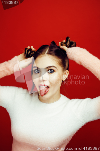 Image of young pretty emitonal posing teenage girl on bright red background, happy smiling lifestyle people concept 