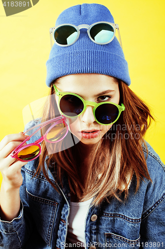 Image of young pretty teenage woman emotional posing on yellow background, fashion lifestyle people concept 