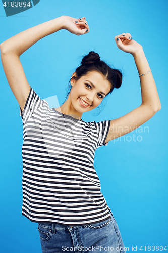 Image of young pretty teenage modern hipster girl posing emotional happy smiling on blue background, lifestyle people concept 