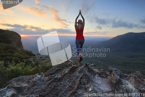 Image of Female fitness stretch to the sky mountain top valley scene