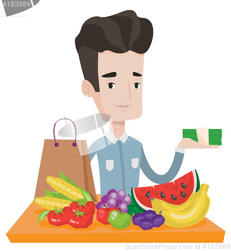 Image of Young man standing at the table with shopping bag