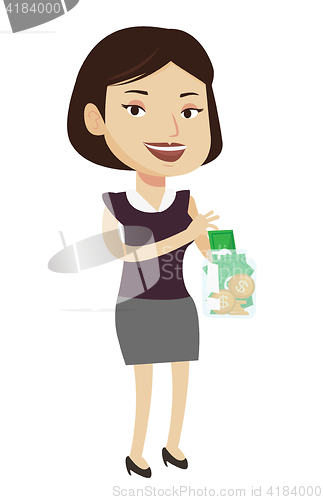 Image of Woman putting dollar money into glass jar.