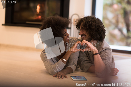 Image of multiethnic couple used tablet computer on the floor