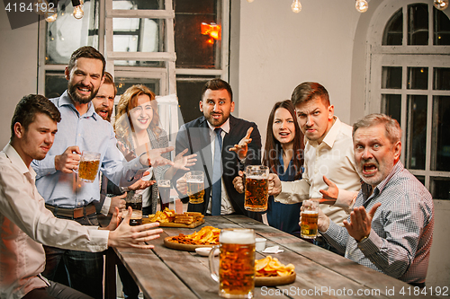 Image of Group of friends enjoying evening drinks with beer