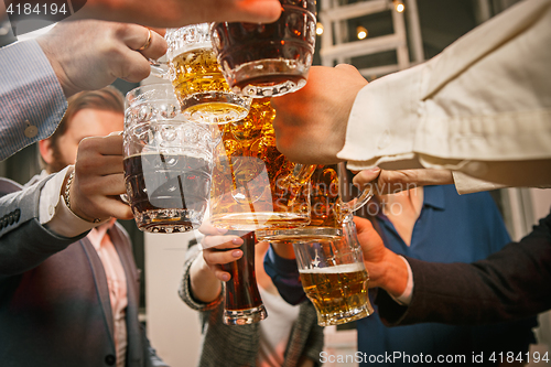 Image of Group of friends enjoying evening drinks with beer