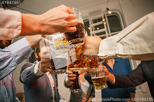 Image of Group of friends enjoying evening drinks with beer