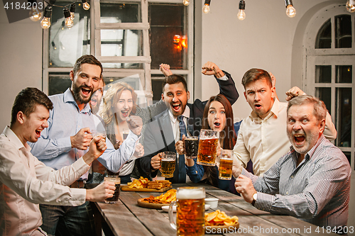 Image of Group of friends enjoying evening drinks with beer