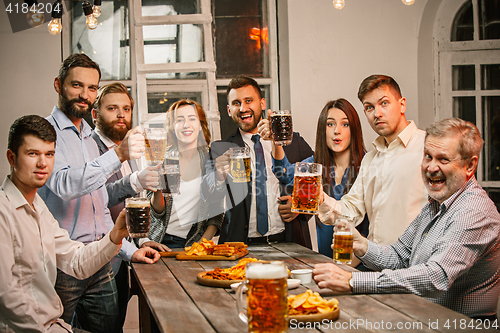 Image of Group of friends enjoying evening drinks with beer