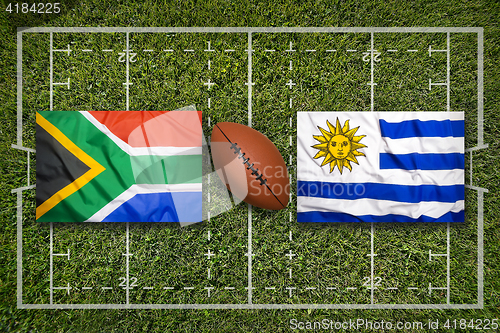 Image of South Africa vs. Uruguay flags on rugby field