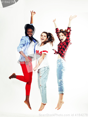 Image of three pretty young diverse nations teenage girl friends jumping happy smiling on white background, lifestyle people concept 