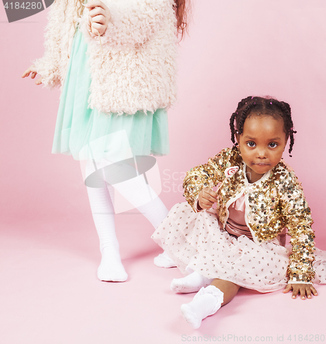 Image of lifestyle people concept: diverse nation children playing together, caucasian boy with african little girl holding candy happy smiling