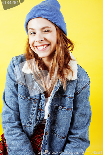 Image of young pretty teenage hipster girl posing emotional happy smiling on yellow background, lifestyle people concept