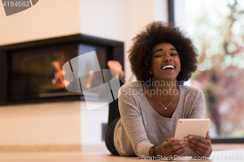 Image of black women used tablet computer on the floor