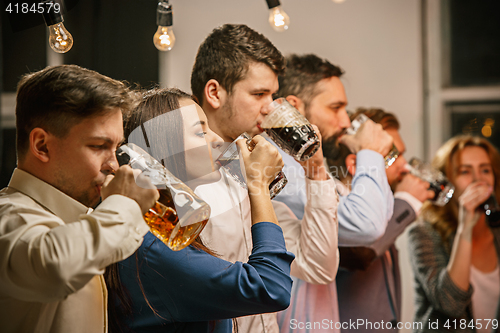 Image of Group of friends enjoying evening drinks with beer