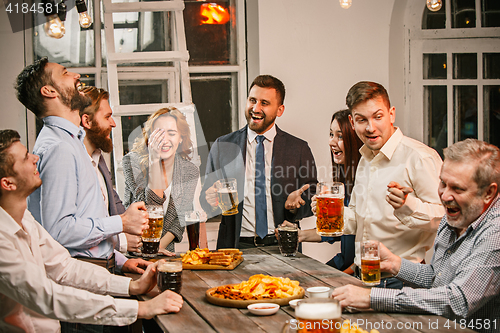 Image of Group of friends enjoying evening drinks with beer