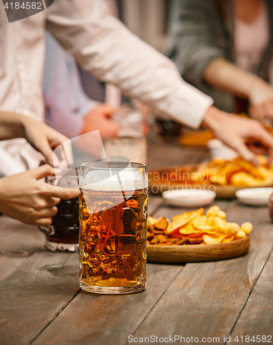 Image of Group of friends enjoying evening drinks with beer