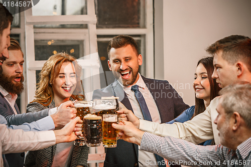 Image of Group of friends enjoying evening drinks with beer