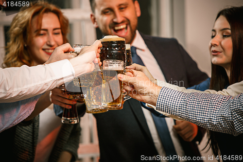 Image of Group of friends enjoying evening drinks with beer