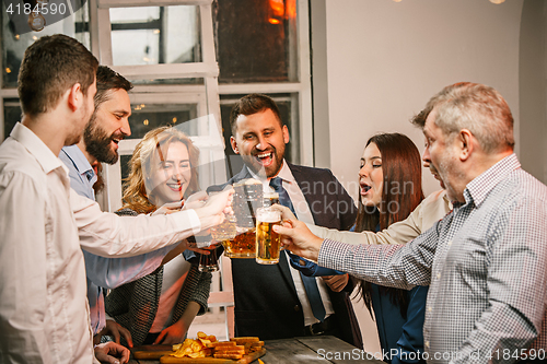 Image of Group of friends enjoying evening drinks with beer