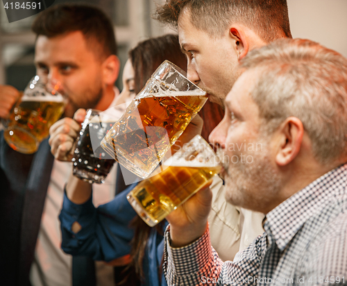 Image of Group of friends enjoying evening drinks with beer