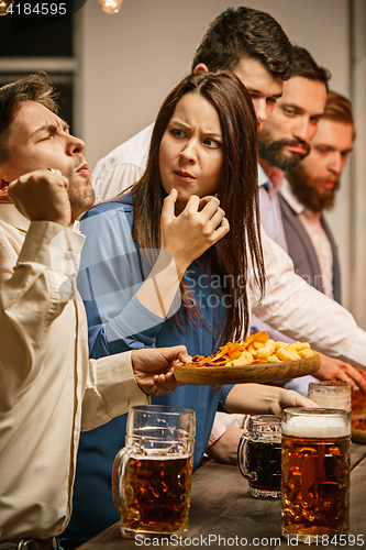 Image of Group of friends enjoying evening drinks with beer