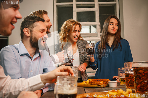 Image of Group of friends enjoying evening drinks with beer