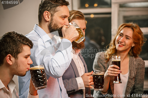 Image of Group of friends enjoying evening drinks with beer