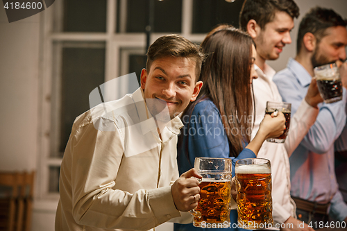 Image of Group of friends enjoying evening drinks with beer