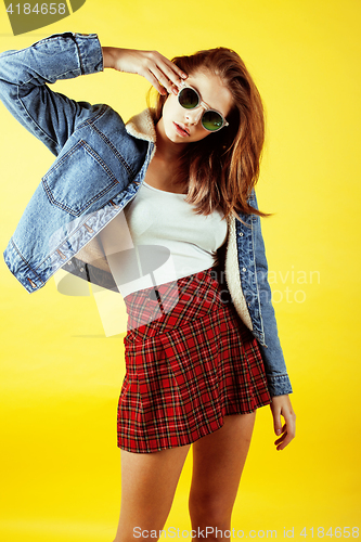 Image of young pretty teenage hipster girl posing emotional happy smiling on yellow background, lifestyle people concept