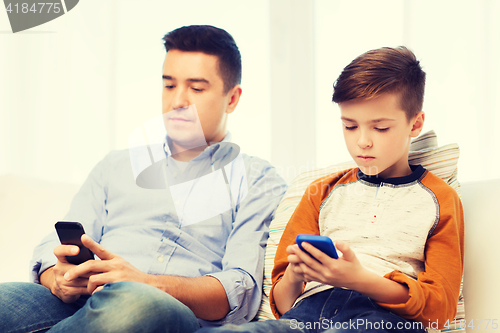 Image of father and son with smartphones at home