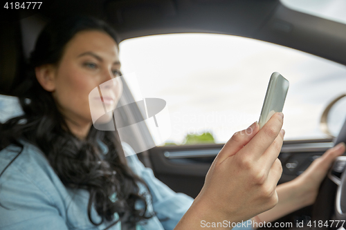 Image of woman driving car with smarhphone