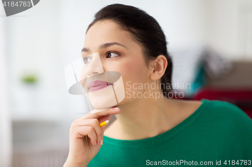 Image of happy young woman with pencil thinking