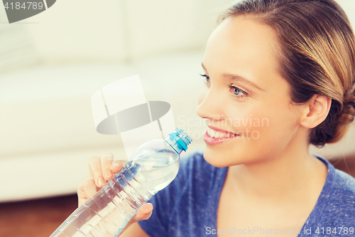 Image of happy woman with water bottle at home