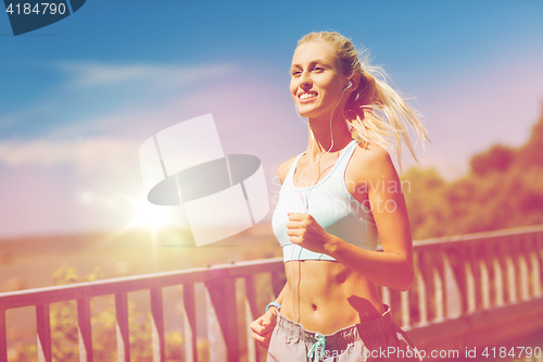 Image of smiling young woman running outdoors