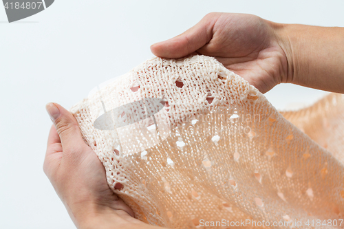 Image of close up of hands with knitted clothing item