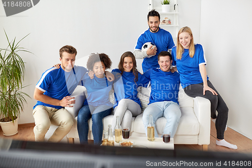 Image of friends or football fans watching soccer at home