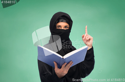 Image of muslim woman in hijab with book over white