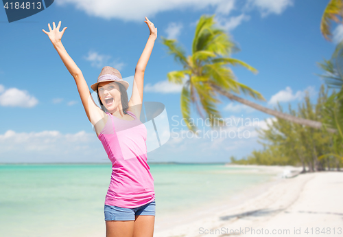 Image of happy young woman in hat on summer beach