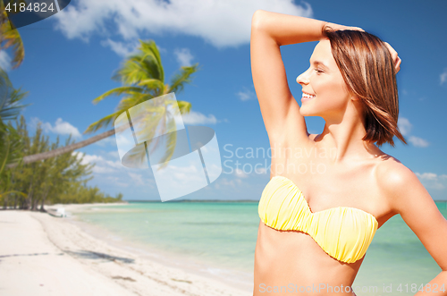 Image of happy woman in bikini swimsuit on tropical beach