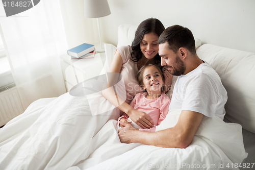 Image of happy family in bed at home