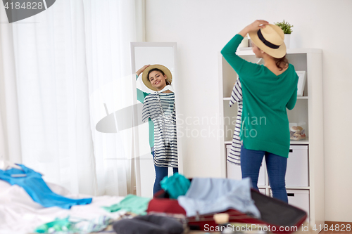 Image of woman packing travel bag at home or hotel room