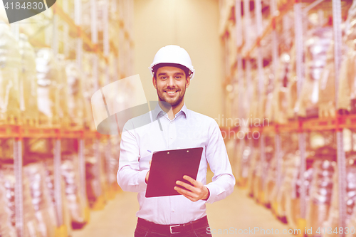 Image of happy businessman with clipboard at warehouse