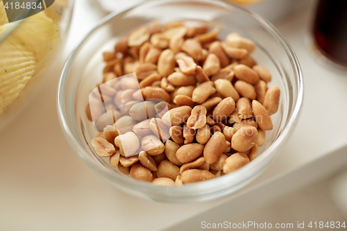 Image of close up of roasted peanuts in glass bowl on table