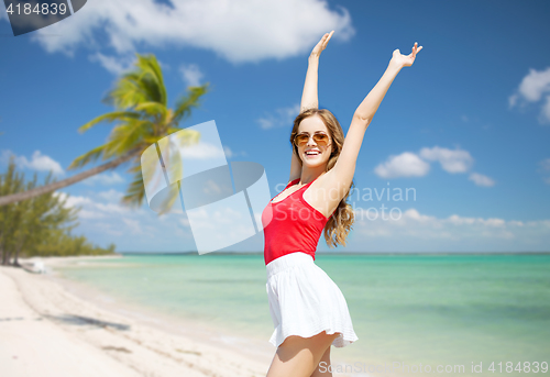 Image of happy young woman in sunglasses on summer beach