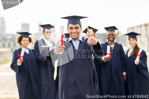 Image of happy student with diploma pointing finger at you