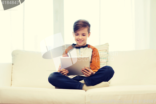 Image of smiling boy with tablet computer at home