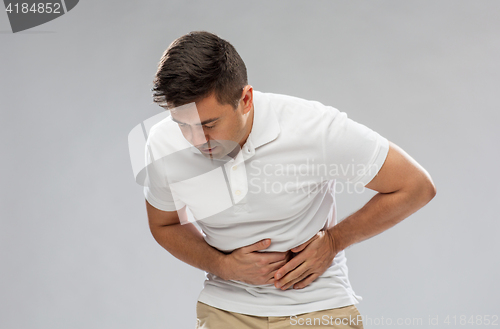 Image of unhappy man suffering from stomach ache