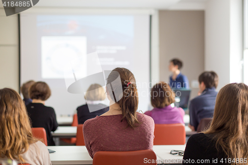 Image of Woman giving presentation in lecture hall at university.