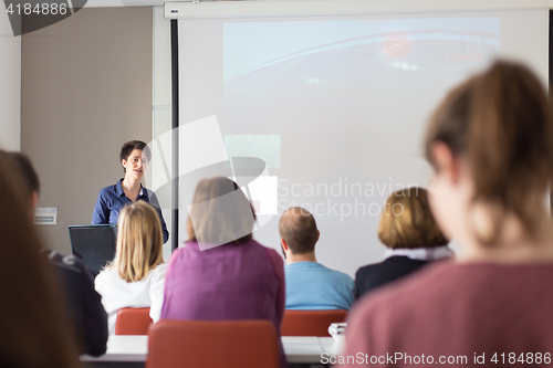 Image of Woman giving presentation in lecture hall at university.