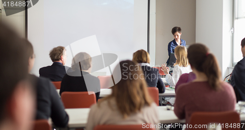 Image of Woman giving presentation in lecture hall at university.